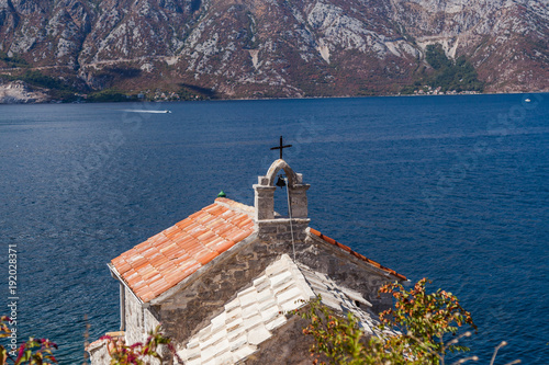 Red roof with a bell of a lighthouse in Lepetan. Montenegro. 