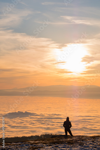 Woman on mountain Schoeckl looking over low stratus to sunset