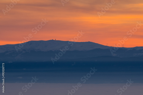 View from mountain Schoeckl over low stratus Koralpe with sunset