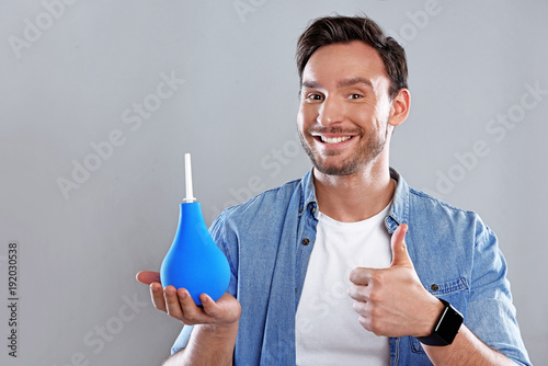 Fotografía Handsome bearded man isolated on a white background holding a blue douche bag an