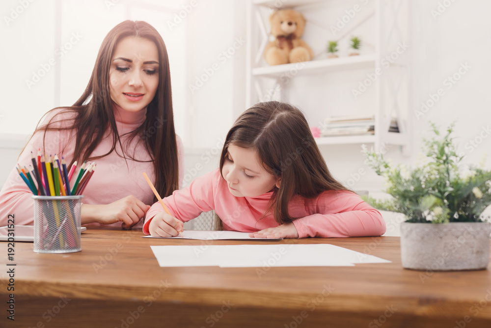 Mother helping her daughter with the homework. Mother helping her daughter with the homework.