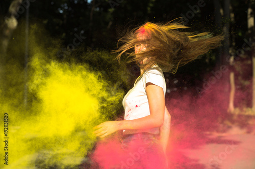 Awesome young woman with wind in hair and vibrant colors exploding around her