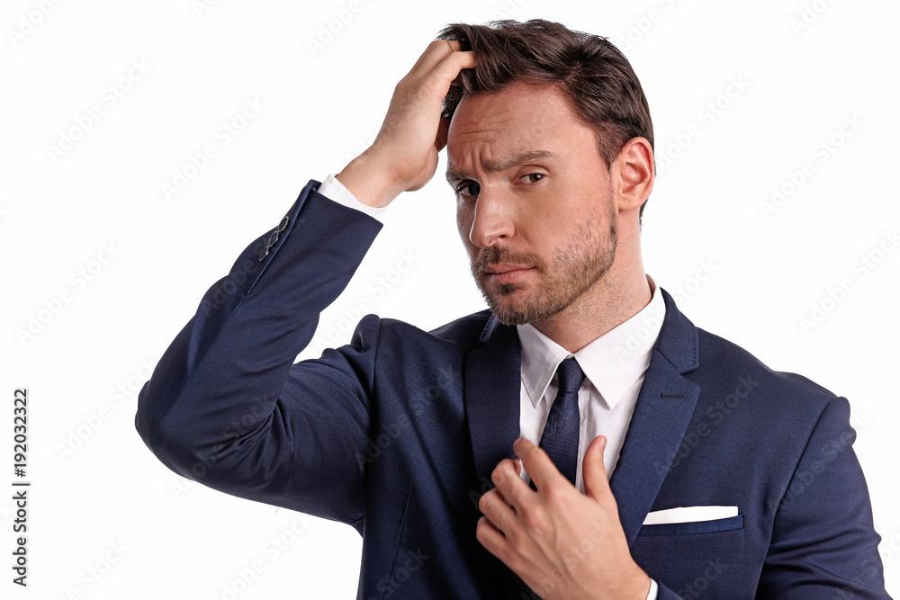Handsome bearded businessman in office suit and tie isolated on white background. Professional bank manager is holding his tie wi a confident face Handsome bearded businessman in office suit and tie isolated on white background. Professional bank manager is holding his tie wi a confident face