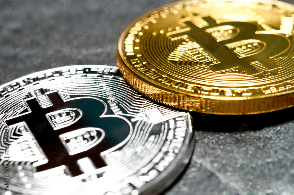 Bitcoin. Two coins are lying on each other, one silver the other gold.
