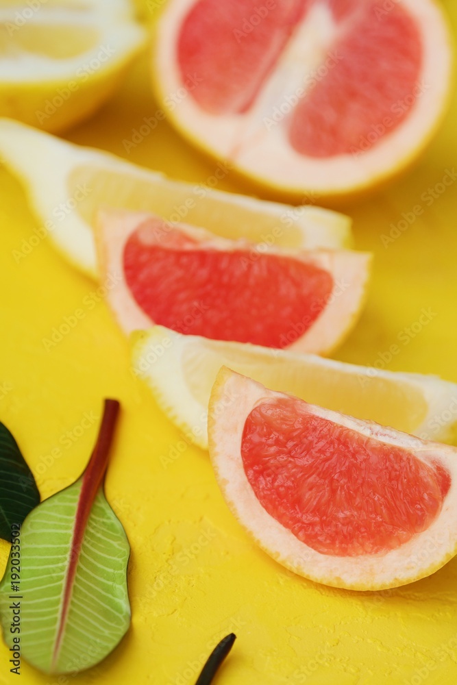 Grapefruit and lemon cut slices on yellow background Grapefruit and lemon cut slices on yellow background