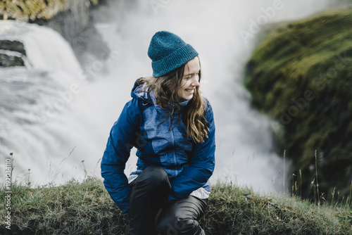 Portrait of smiling Caucasian woman sitting near waterfall photo