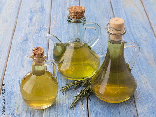 olive oil in a bottle on a blue wooden table. 