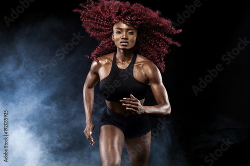 A strong athletic  female sprinter  running at sunrise wearing in the sportswear  fitness and sport motivation concept with copy space.