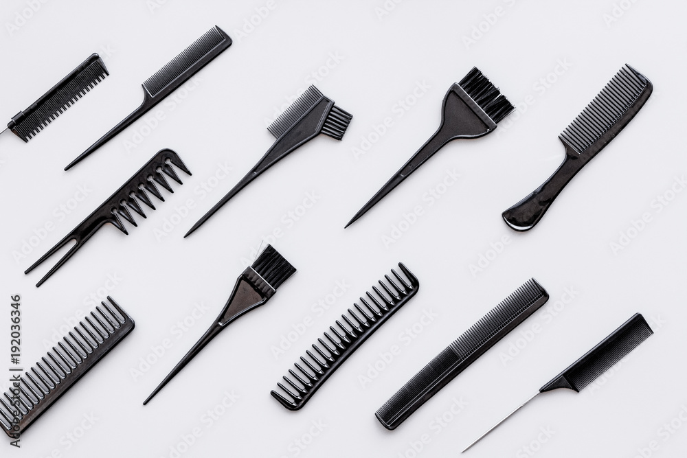 Hairdressing tools. Pattern with various combs and brushes on grey background top view Hairdressing tools. Pattern with various combs and brushes on grey background top view