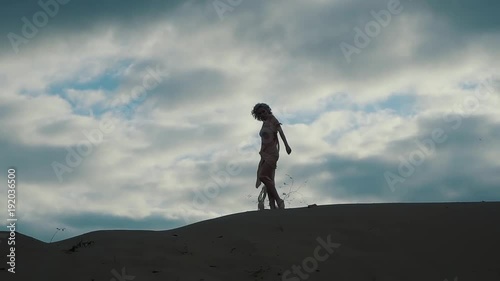 Wallpaper Mural Silhoutte of a fabulous woman standing and posing on sand hill outdoor. Wind is blowing on her half naked body. Torontodigital.ca