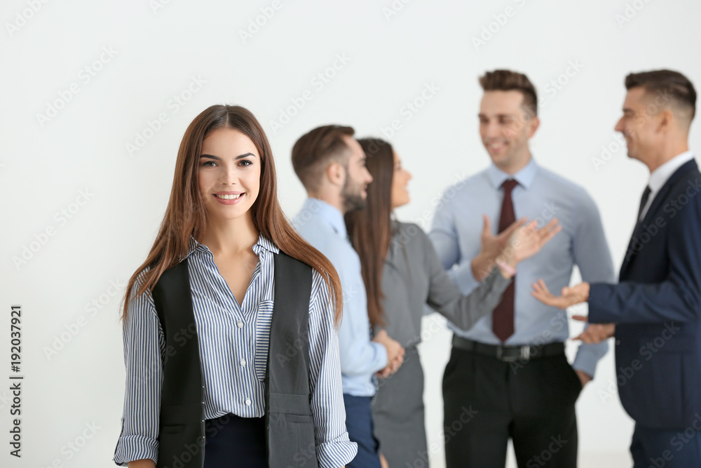 Young smiling businesswoman and her team on light background Young smiling businesswoman and her team on light background