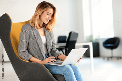 Young woman with laptop sit...