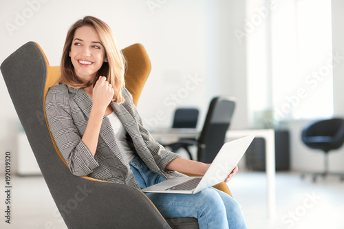 Young woman with laptop sit...