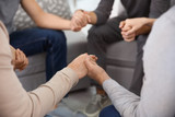 Young people holding hands during group therapy, closeup