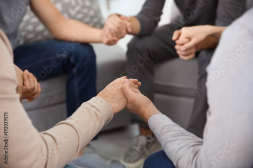 Young people holding hands during group therapy  closeup