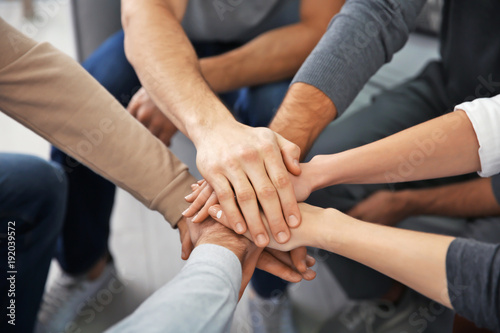 Young people putting hands together during group therapy  closeup