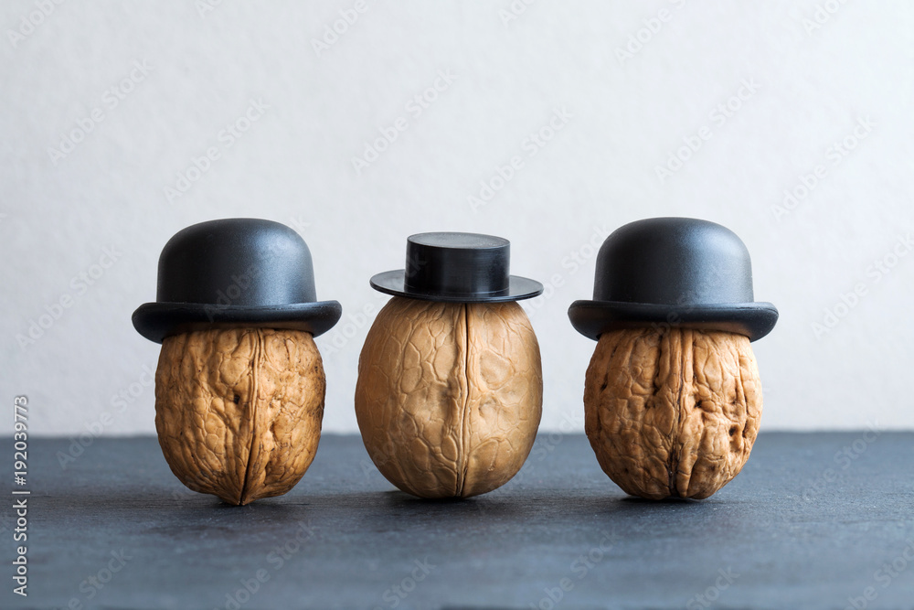 Fototapeta Dżentelmenów orzechów włoskich czarni kapelusze na kamieniu i szarym tle. Plakat kreatywny projekt żywności. Makro- widok selekcyjnej ostrości fotografia