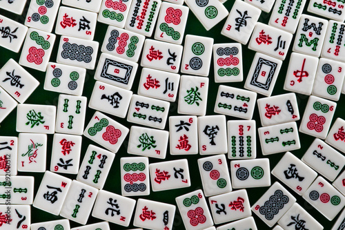 White-green tiles for mahjong on on green cloth background photo