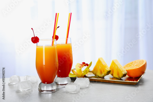 Φωτογραφία Glasses with cocktail Sex on the Beach against light background