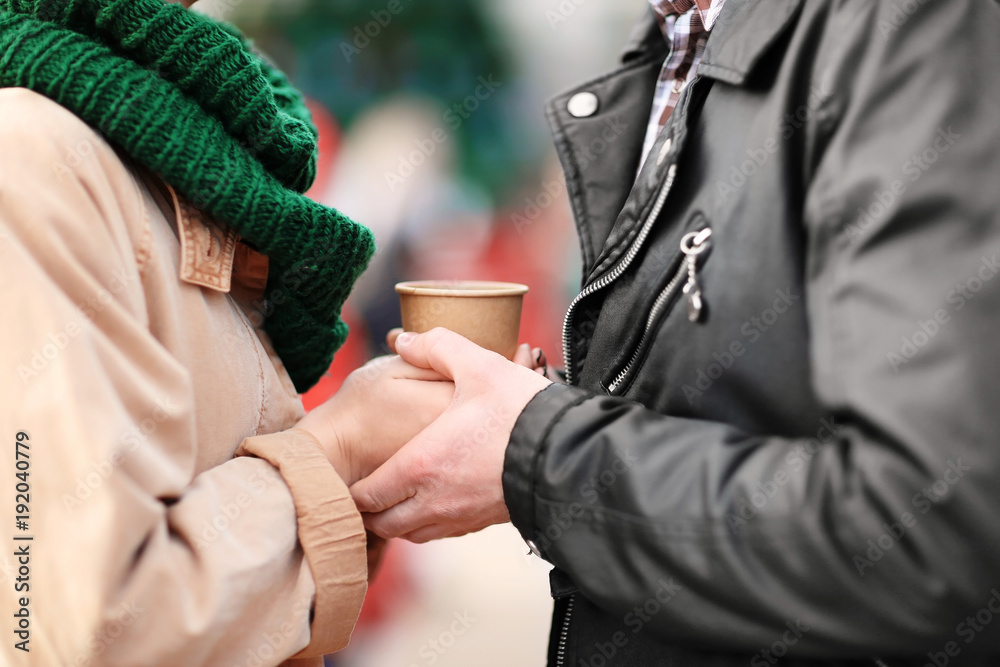 Young couple in warm clothes outdoors, closeup