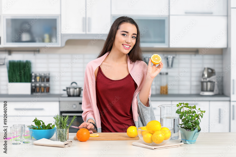 Young woman preparing tasty lemonade in kitchen Young woman preparing tasty lemonade in kitchen
