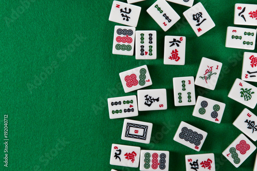 White-green tiles for mahjong on on green cloth background. Emty space on the left photo