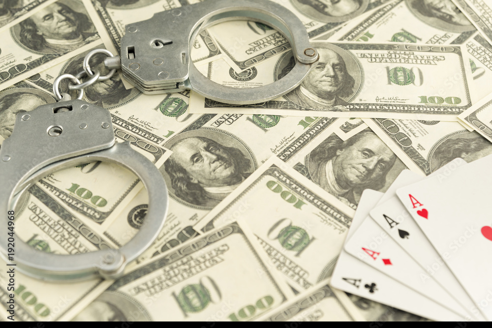 handcuffs, banknotes of dollars, four ace of playing cards. ban on gambling handcuffs, banknotes of dollars, four ace of playing cards. ban on gambling