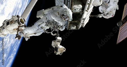 Astronaut Spacewalk Using Robotic Arm at Space Station Talking Photo some elements furnished by NASA images