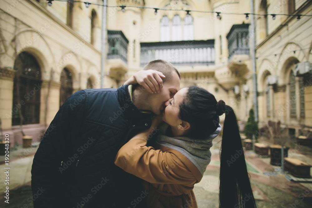 Caucasian couple kissing in courtyard Caucasian couple kissing in courtyard