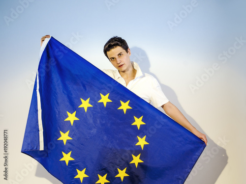 Happy brunette guy with a European flag