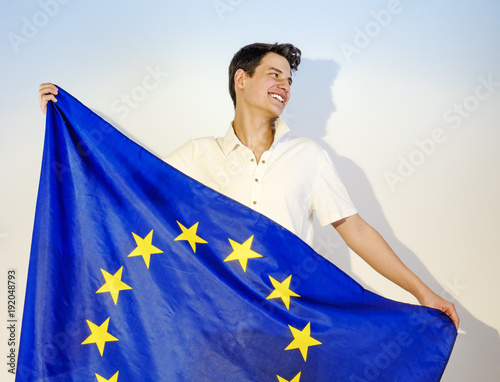 Happy brunette guy with a European flag