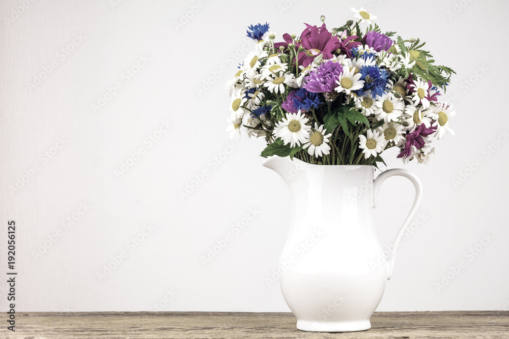 Wildflowers in white ceramic jug. Wildflowers in white ceramic jug.