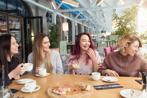 Gossipgirls  freindship concept. Female friends with tea and coffee speaking in cafe  gossip and news. Smiling women laughing  talking and smiling together in coffee shop
