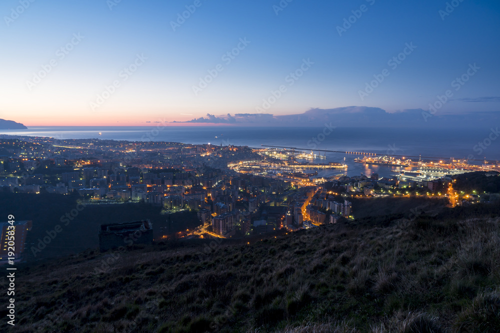 Night panorama of Genoa, Italy. View of the harbor from the hills surrounding the city.