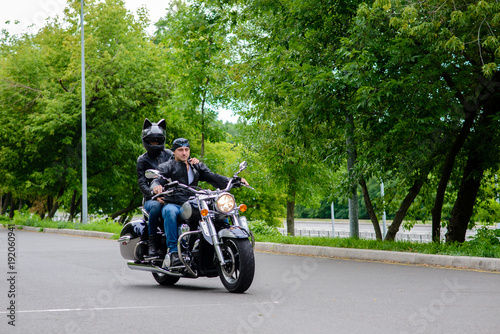 A man and a woman ride a motorbike on the road.