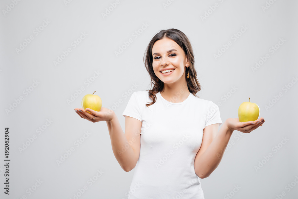 Young happy smiling woman balance with two apple, isolated on white Young happy smiling woman balance with two apple, isolated on white