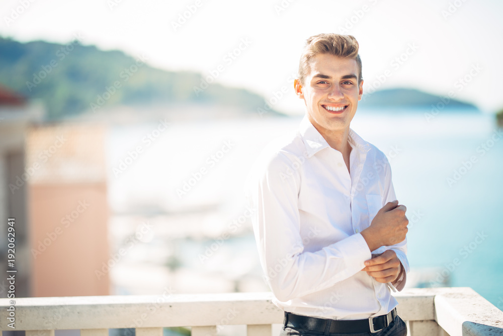 Young handsome man enjoying stay at luxury resort hotel with panoramic view on the sea.Smiling cheerful business man at a earned tropical vacation.Summer vacation traveling.Cruise Young handsome man enjoying stay at luxury resort hotel with panoramic view on the sea.Smiling cheerful business man at a earned tropical vacation.Summer vacation traveling.Cruise