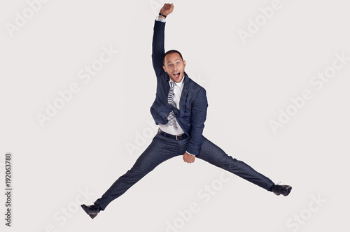 A businessman in a suit jumps for joy. The guy jumps happily.