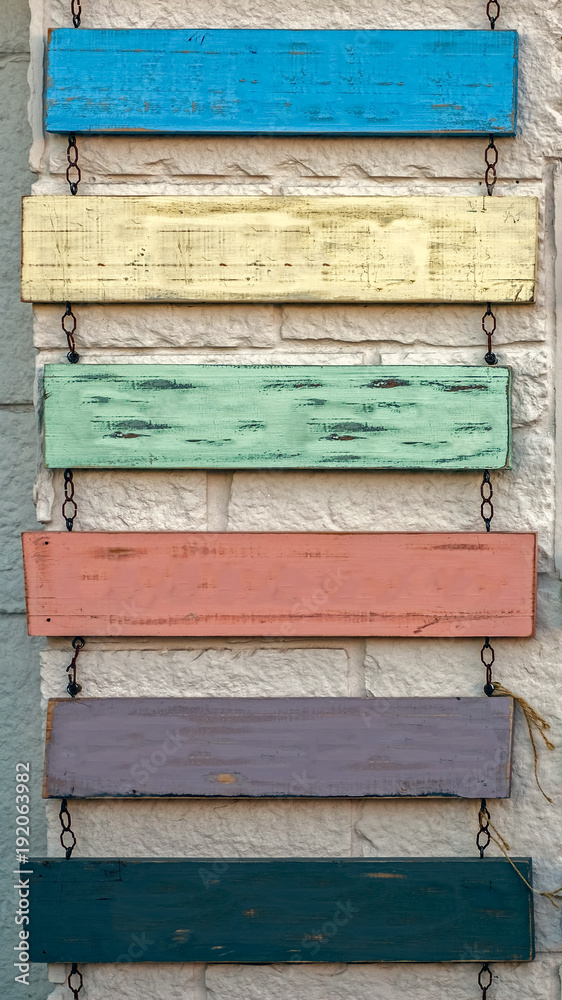 Blank rustic sign hanging on chains against old wall Blank rustic sign hanging on chains against old wall