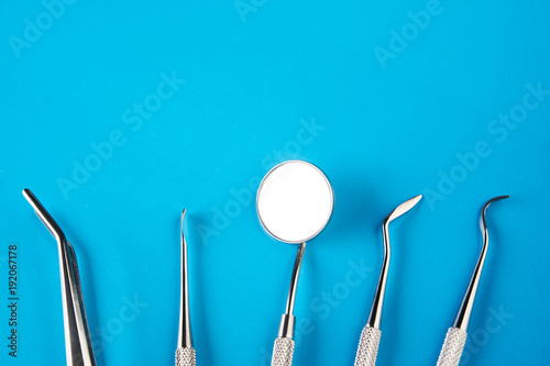 Set of Dentist's medical equipment tools. Stainless steel dental equipment on blue background with copy space. 