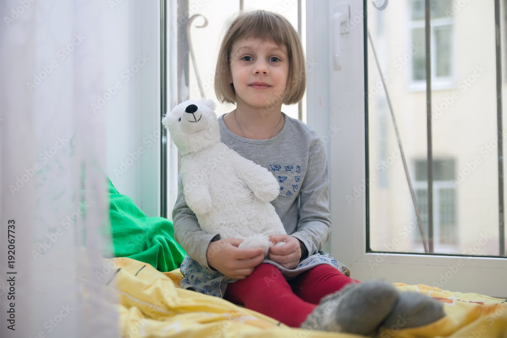 little girl on cozy window-sill with bear toy little girl on cozy window-sill with bear toy