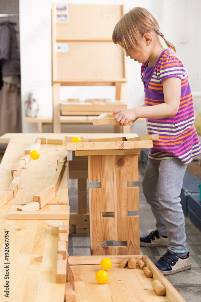 girl playing with wooden puzzles. - obrazy, fototapety, plakaty 