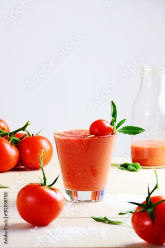 Fresh tomato juice in the glass on the white background © topotishika