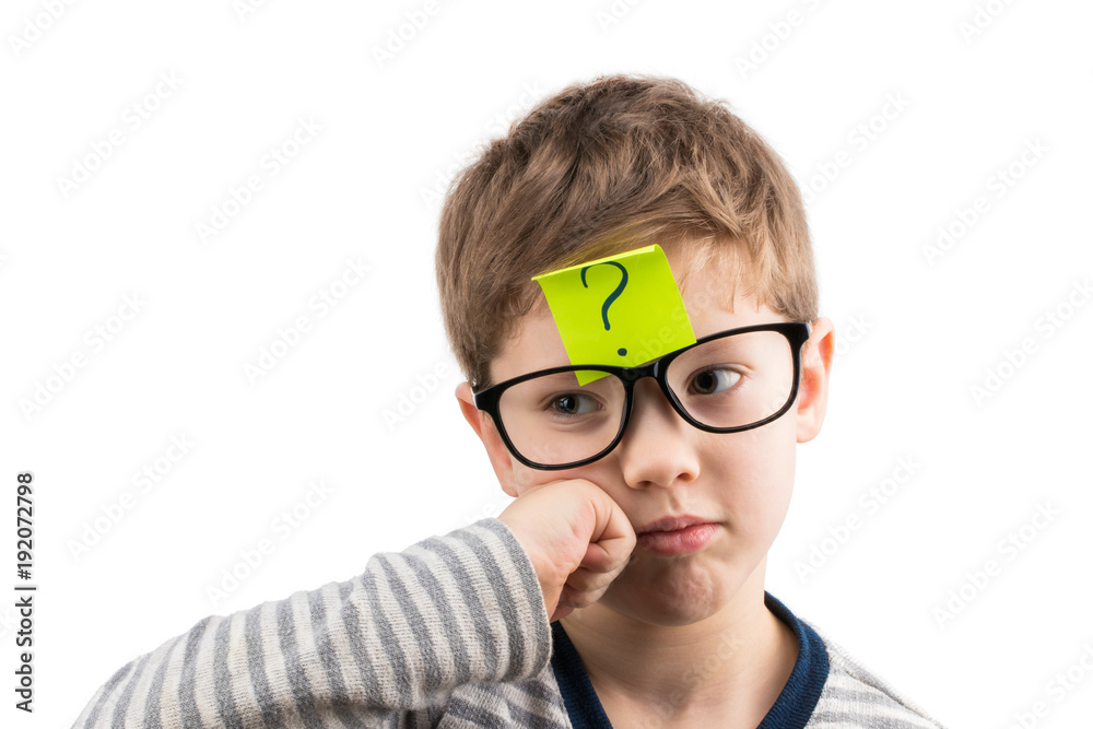 Confused boy thinking with question mark on sticky note on forehead Confused boy thinking with question mark on sticky note on forehead