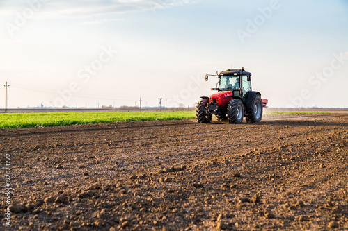 Farmer fertilizing arable land with nitrogen  phosphorus  potassium fertilizer