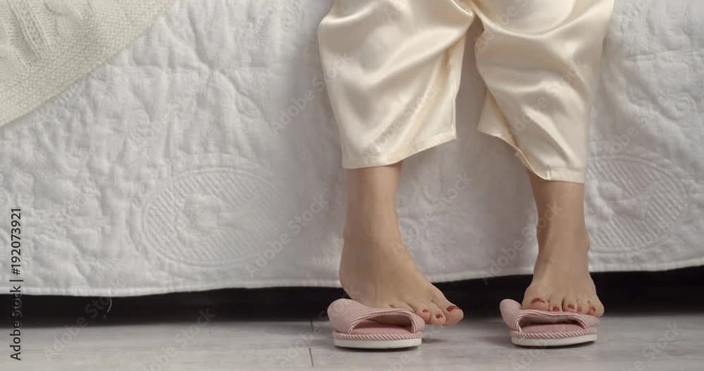 Pink fashion slippers standing next to bed in cozy bedroom. Pink fashion slippers standing next to bed in cozy bedroom.