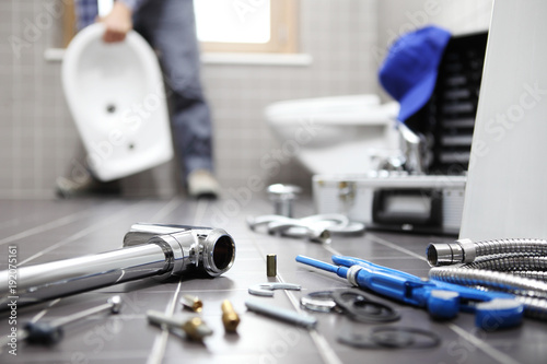 plumber at work in a bathroom, plumbing repair service, assemble and install concept