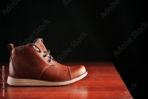 winter brown leather boots on a dark background. Modern fashion and style.