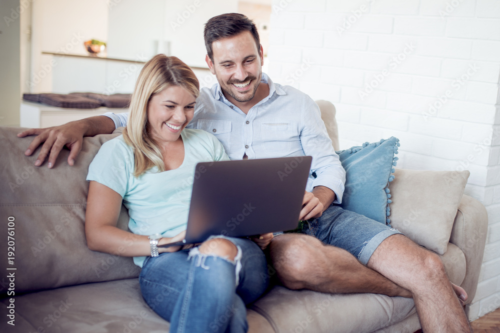 Couple on sofa using a laptop computer. Couple on sofa using a laptop computer.
