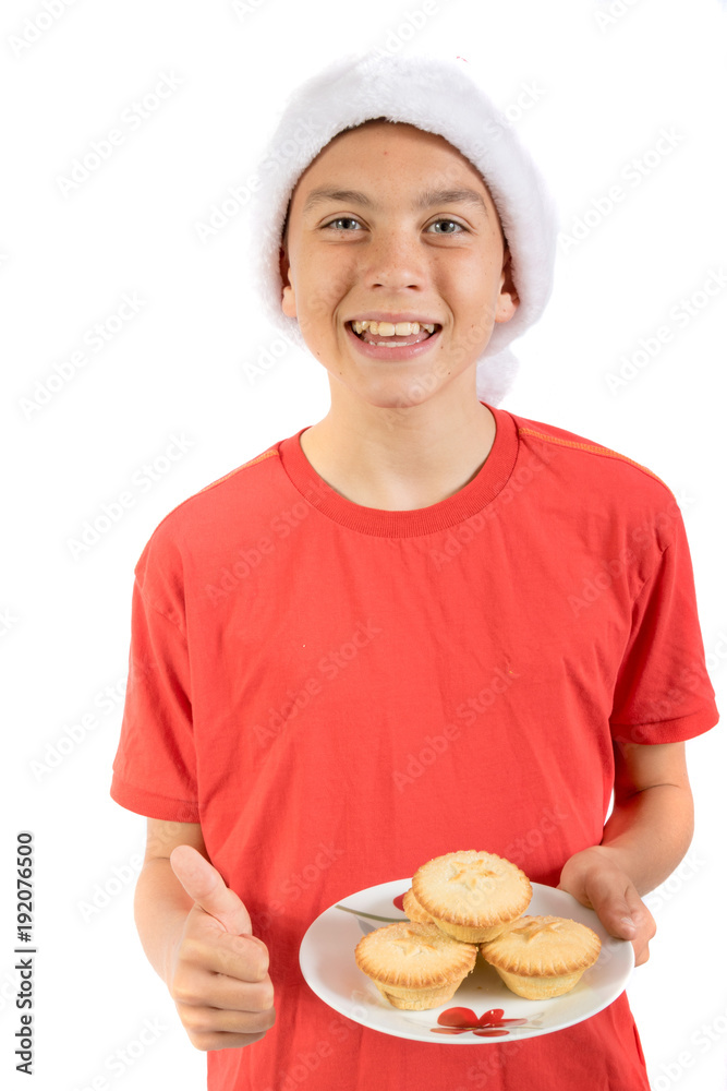 Teenage boy isolated on white background with a plate of mince pies Teenage boy isolated on white background with a plate of mince pies